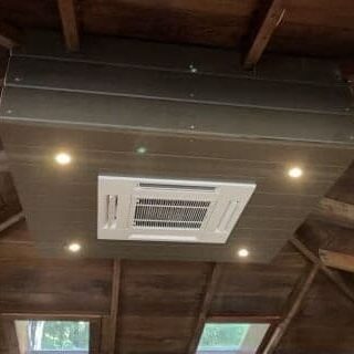 A ceiling mounted air conditioner with lights on it.