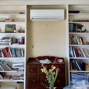 A room with bookshelves and a dresser in it